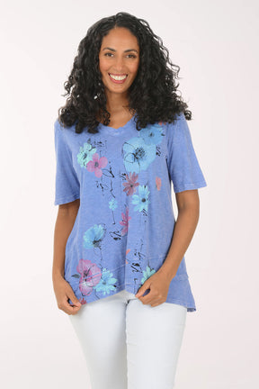 Woman wearing a blue floral tunic against a white background