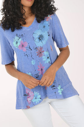 Woman wearing a blue floral tunic against a white background