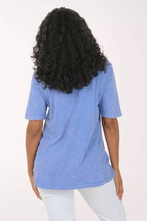 Woman wearing a blue floral tunic against a white background