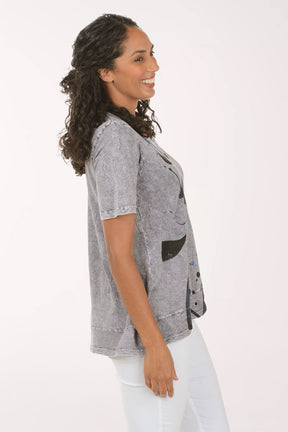 Woman wearing a patterned gray shirt on a white background