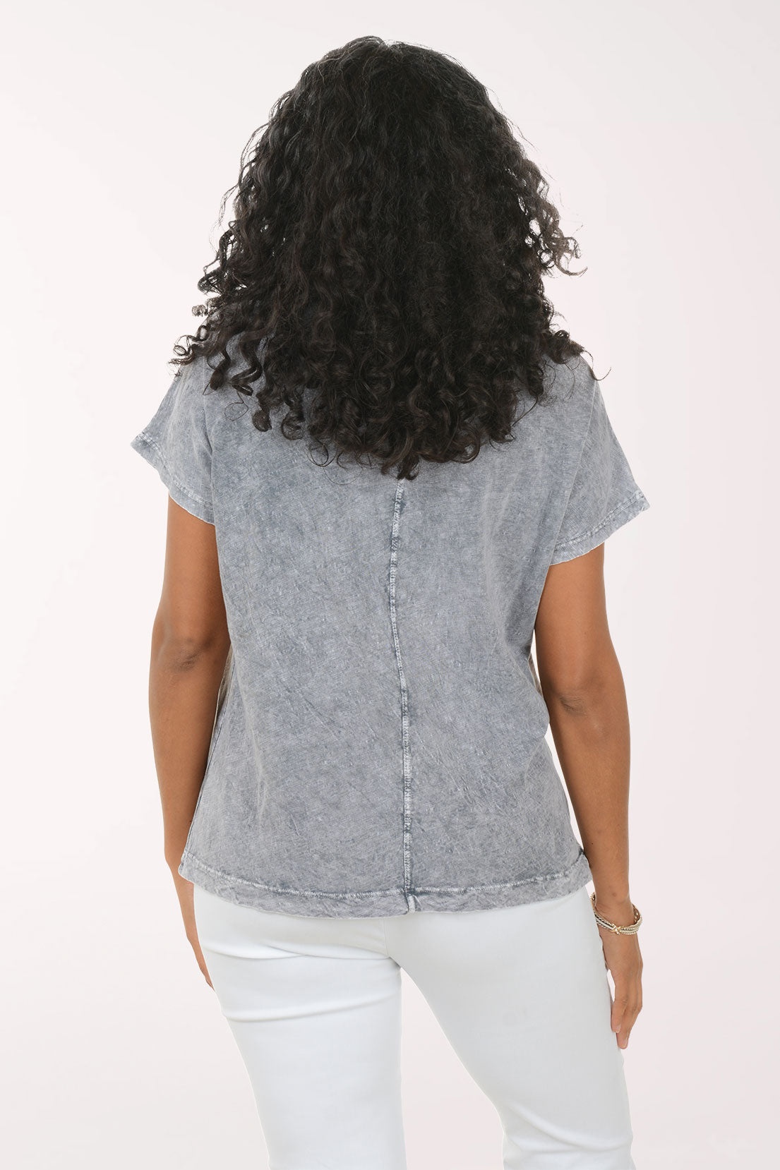 Woman wearing a patterned gray shirt on a white background