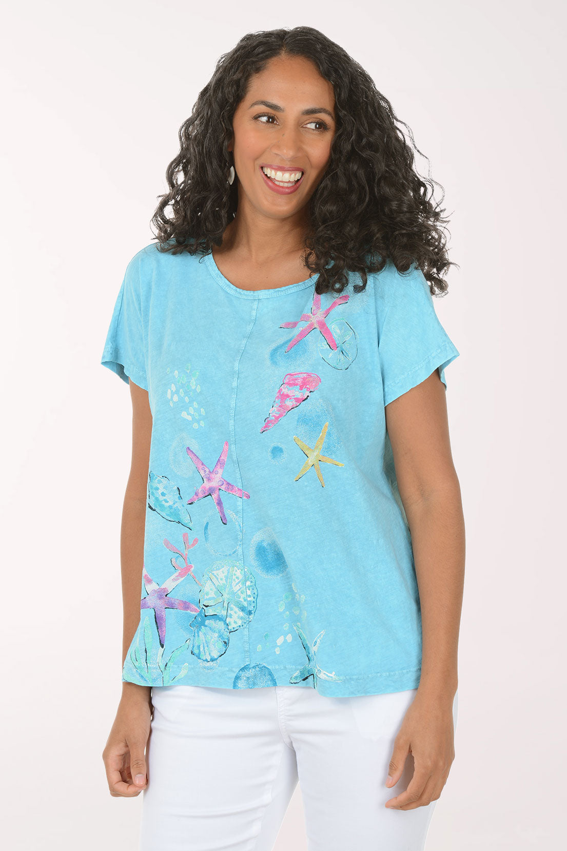 Woman wearing a blue t-shirt with colorful starfish designs on a white background