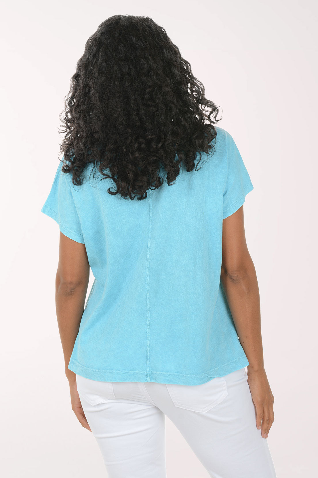 Woman wearing a blue t-shirt with colorful starfish designs on a white background