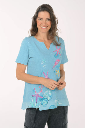 Woman wearing a short sleeve blue top.