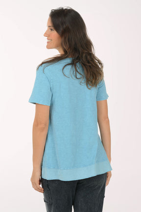 Woman wearing a short sleeve blue top.