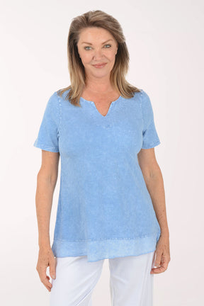 Woman wearing a light blue top and white pants on a white background