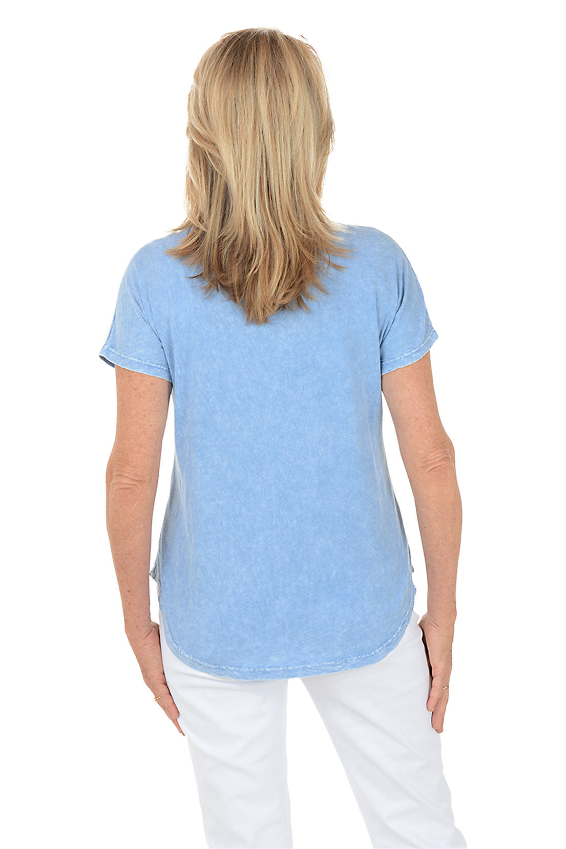 Woman wearing a blue floral graphic t-shirt against a white background. Back shot.