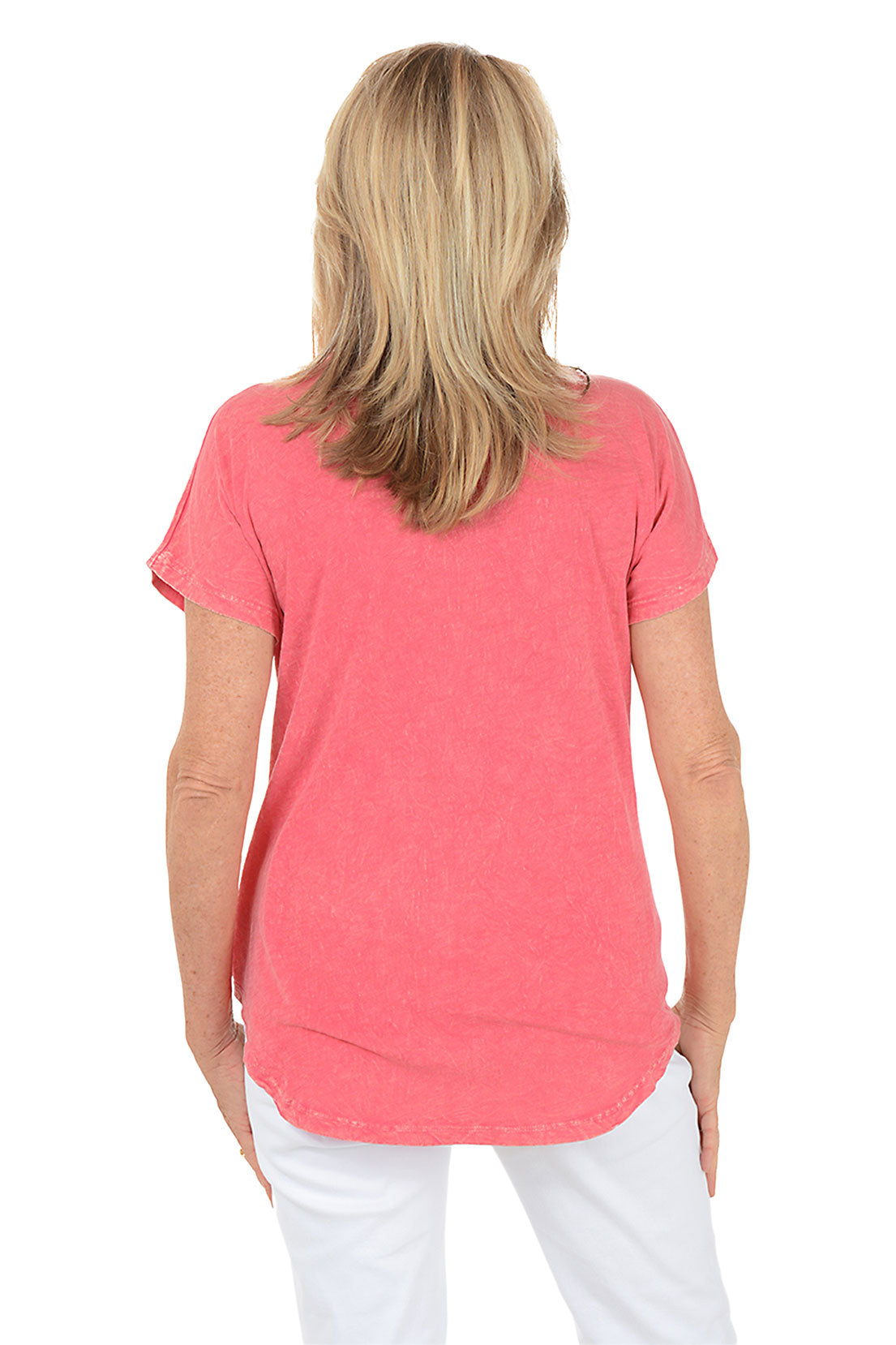 Woman wearing a pink t-shirt with orange floral designs on a white background. Back shot.