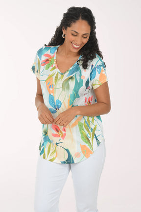 Woman wearing a colorful floral blouse against a white background