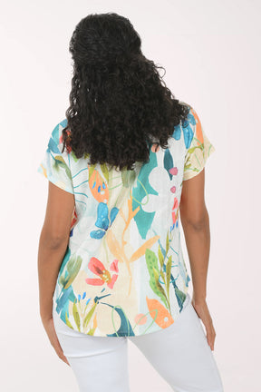Woman wearing a colorful floral blouse against a white background