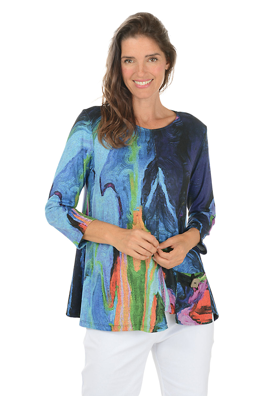 Woman wearing a colorful long-sleeve top with abstract design on a white background.