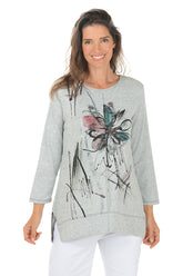 Woman wearing a gray sweater with a colorful butterfly design on a white background. 