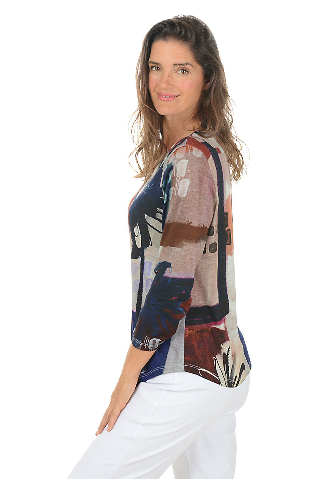Woman wearing a colorful floral-patterned top on a white background. Side shot.