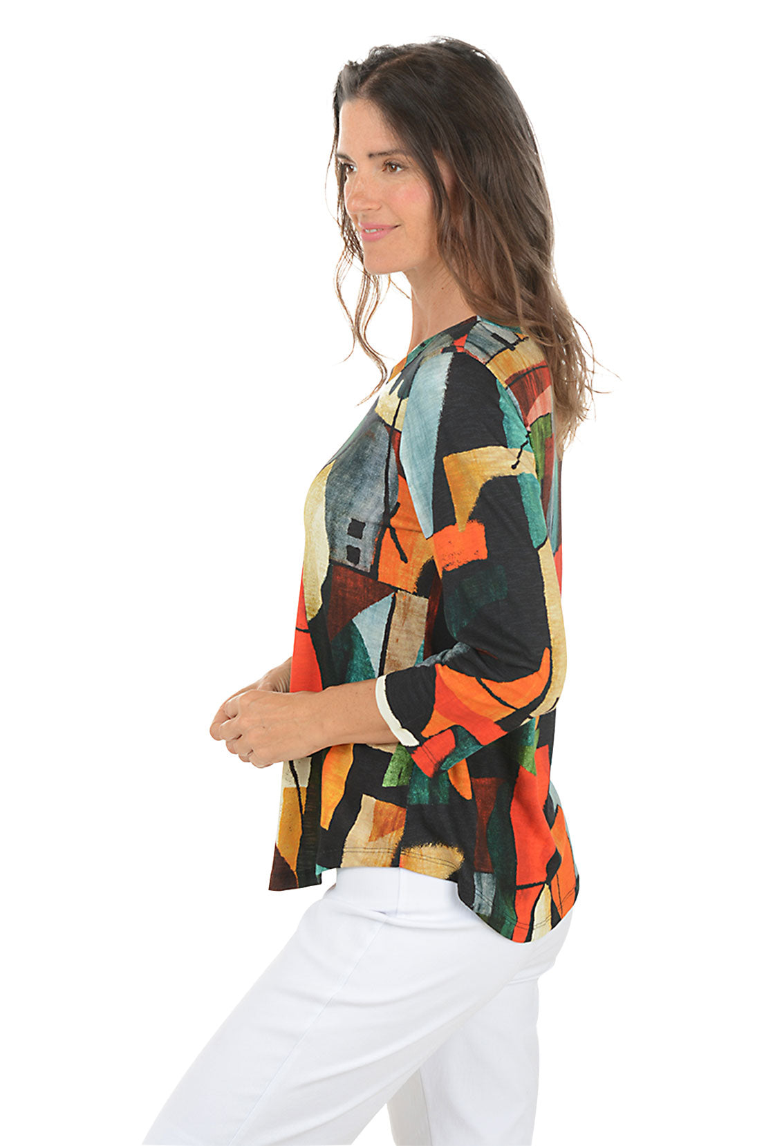 Woman wearing a colorful abstract patterned top on a white background. Side shot.