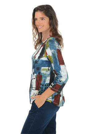 Woman wearing a colorful abstract patterned top on a white background. Side shot.