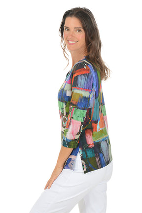 Woman wearing a colorful abstract patterned top on a white background. Side shot.