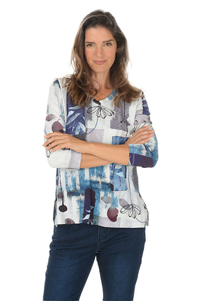 Woman wearing a colorful patterned top with blue jeans on a white background. Second front shot.