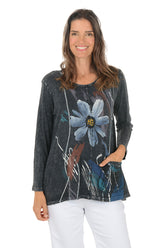 Woman wearing a dark denim shirt with floral design on a white background.