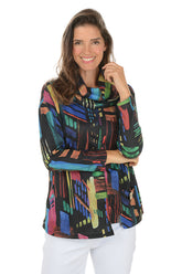 Woman wearing a colorful patterned top on a white background.