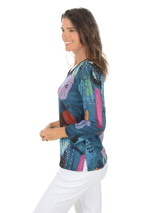 Woman wearing a colorful abstract patterned top on a white background. Side shot.