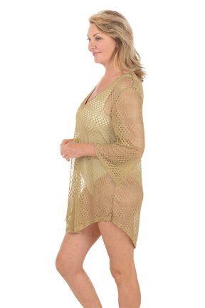 Woman wearing a gold lace cover-up on a white background. Side shot.