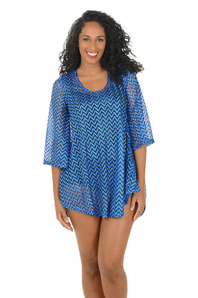 Woman wearing a blue chevron patterned cover-up on a white background.