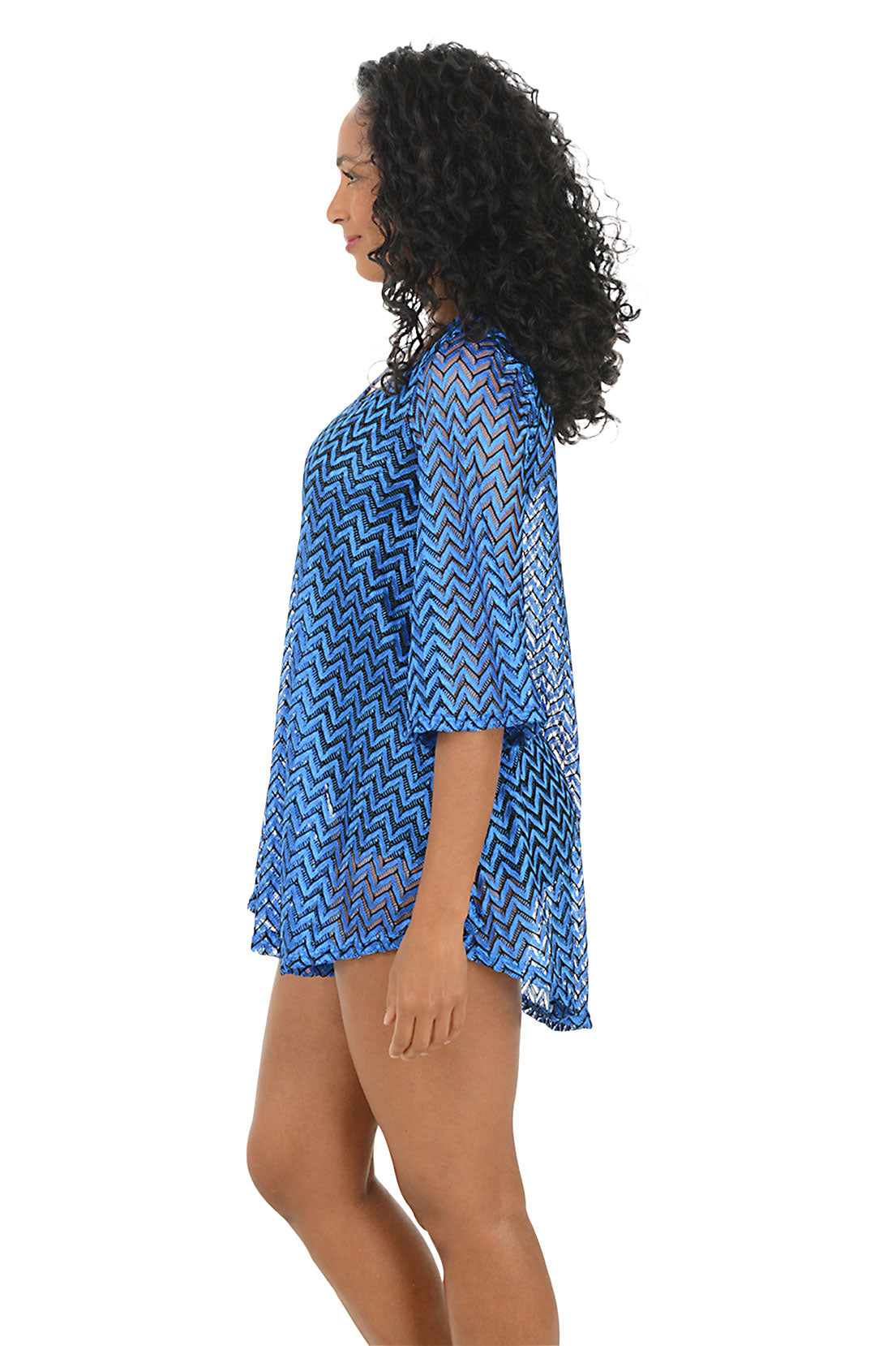 Woman wearing a blue chevron patterned cover-up on a white background. Side shot.