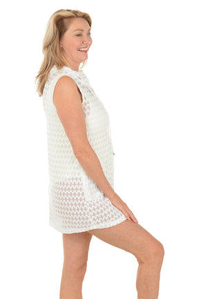 Woman wearing a white sleeveless dress on a white background. Side shot.