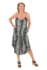 Woman wearing a black and white patterned dress on a white background.