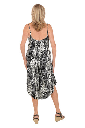 Woman wearing a black and white patterned dress on a white background.  Back shot.