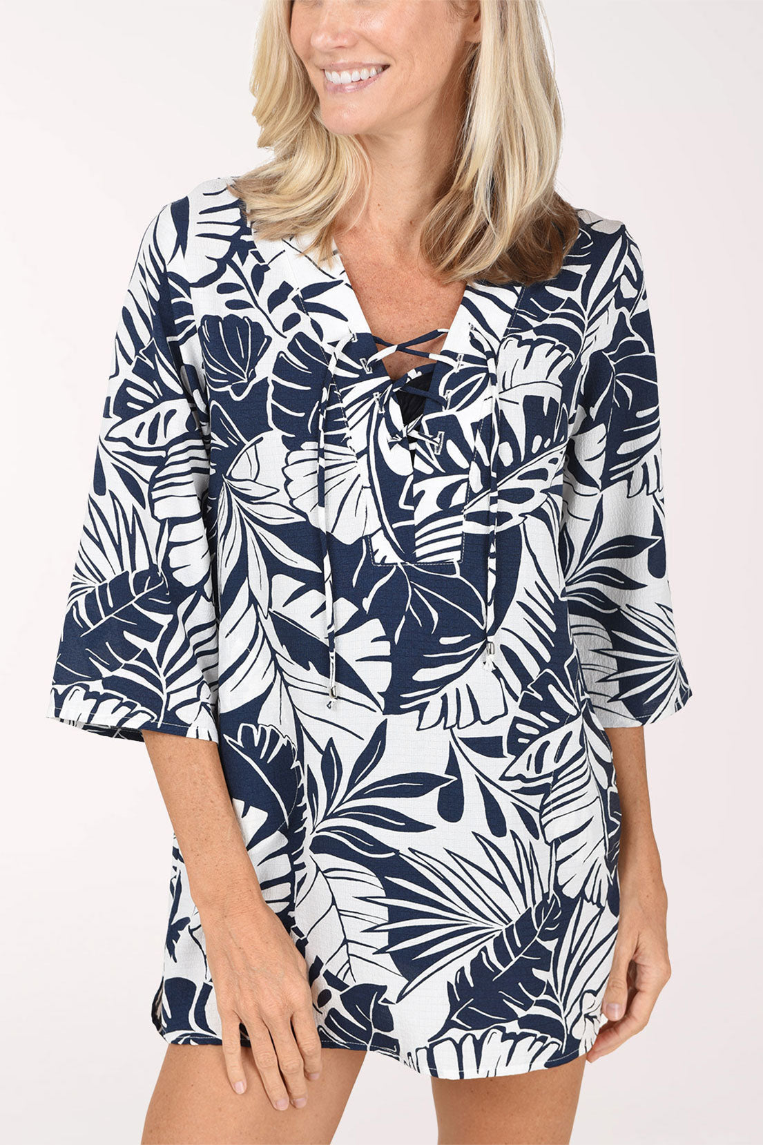 A close view of the navy and white palm leaf tunic cover-up showing the lace-up V-neckline and 3/4 sleeves.
