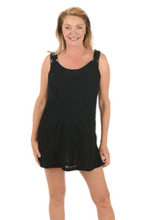 Woman wearing a black sleeveless dress on a white background.