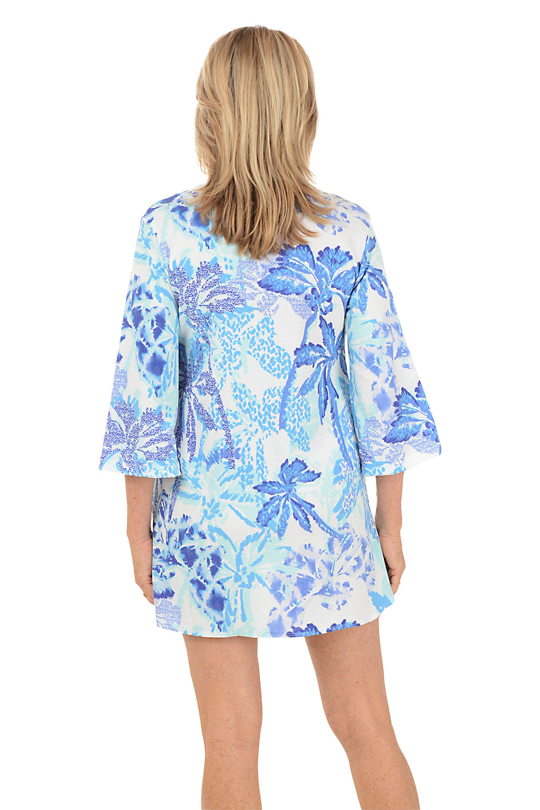Woman wearing a blue floral cover-up on a white background. Back shot.