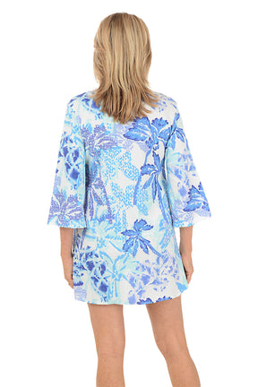 Woman wearing a blue floral cover-up on a white background. Back shot.