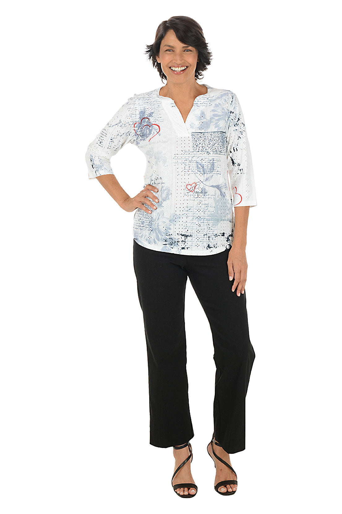 Woman wearing a white blouse with black patterns and black pants on a white background