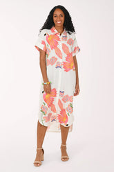 Woman wearing a white multi dress with a parrot print.