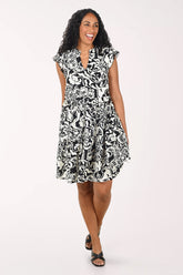 Woman wearing a black and white patterned dress on a white background