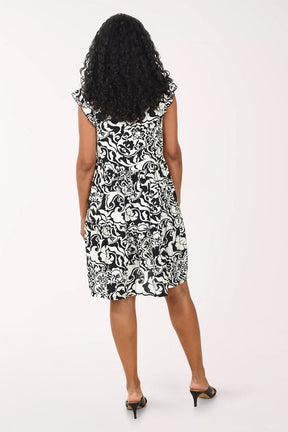 Woman wearing a black and white patterned dress on a white background