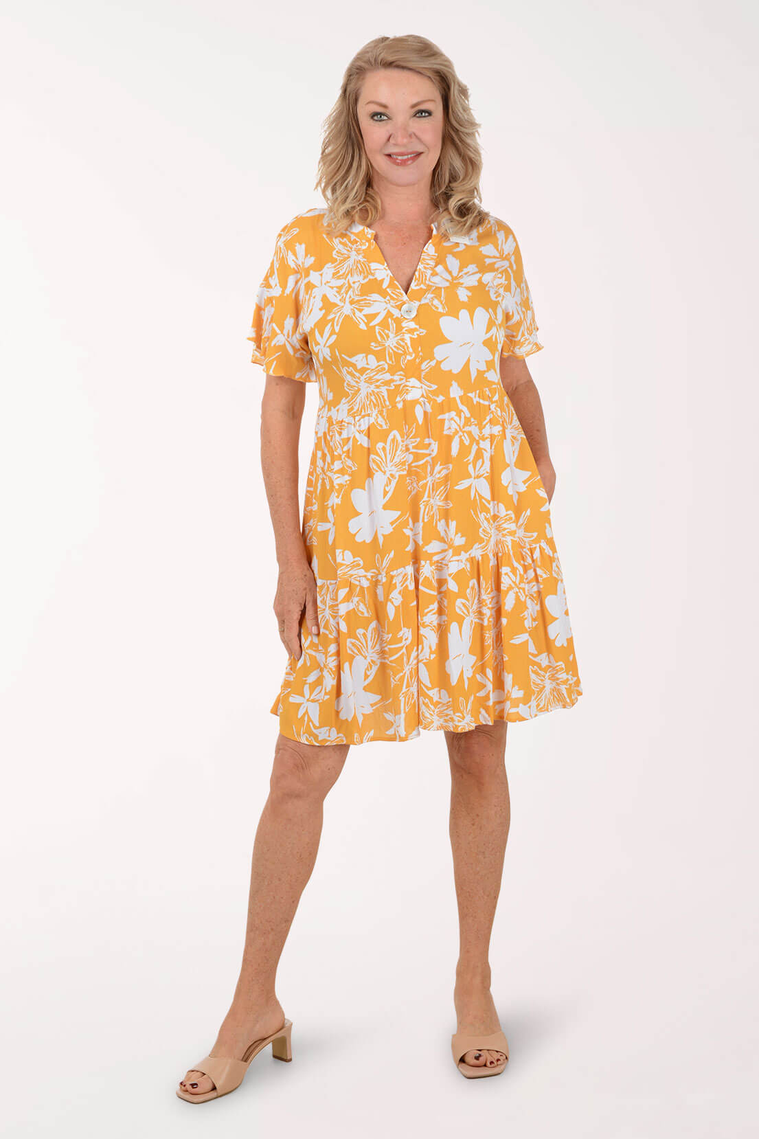 Woman wearing a yellow floral dress on a white background