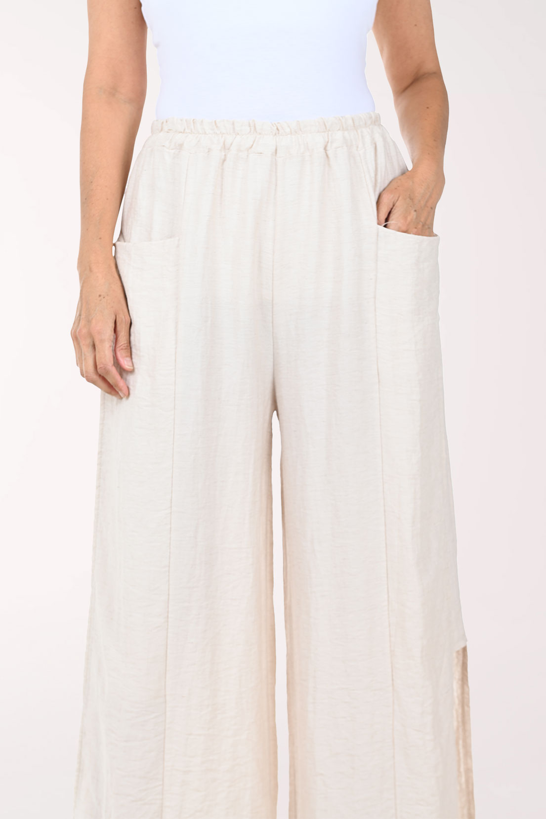Person wearing white wide-leg pants on a white background
