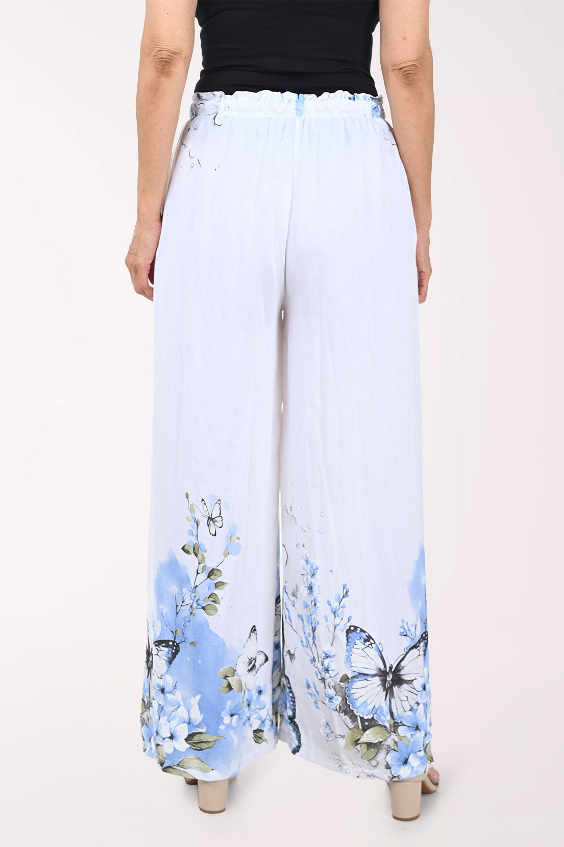 White pants with blue butterfly pattern worn by a person on a white background