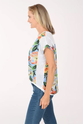 Woman wearing a colorful floral t-shirt and blue jeans on a white background