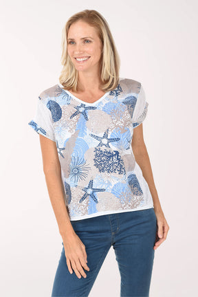 Woman wearing a white t-shirt with blue starfish pattern on a white background