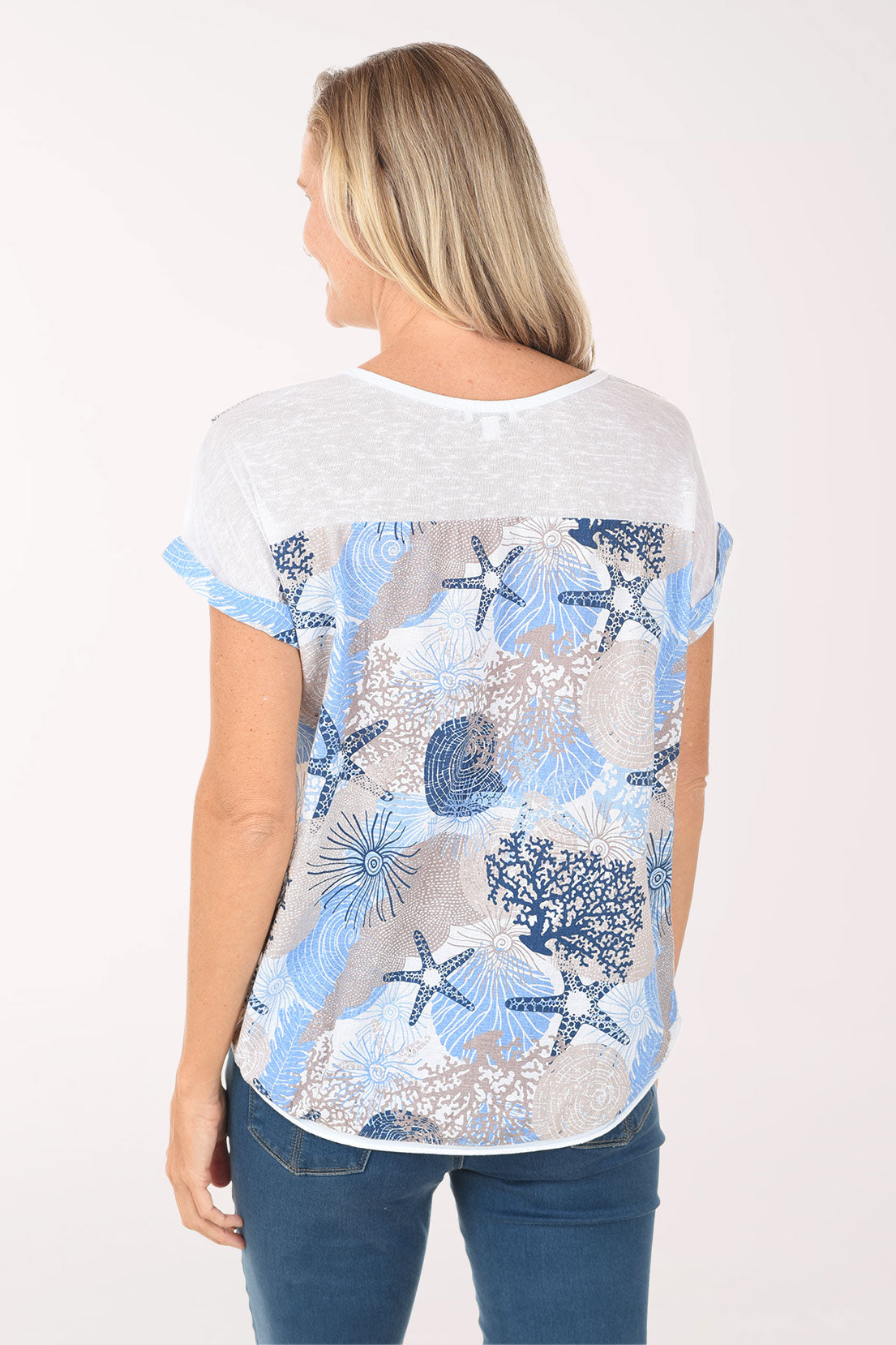 Woman wearing a white t-shirt with blue starfish pattern on a white background