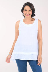 Woman wearing a white sleeveless top and blue jeans on a white background