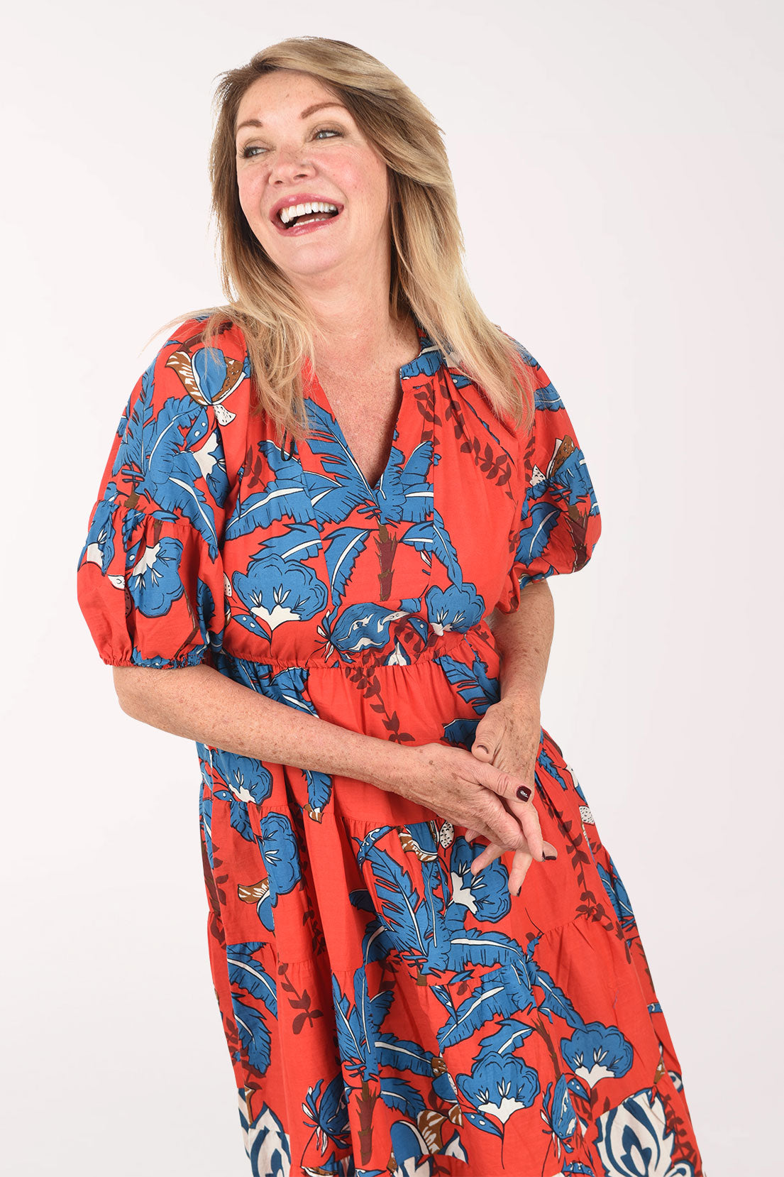 Woman wearing a red floral dress on a white background