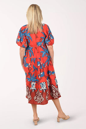 Woman wearing a red floral dress on a white background