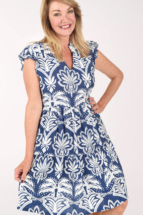 Woman wearing a blue and white patterned dress on a white background