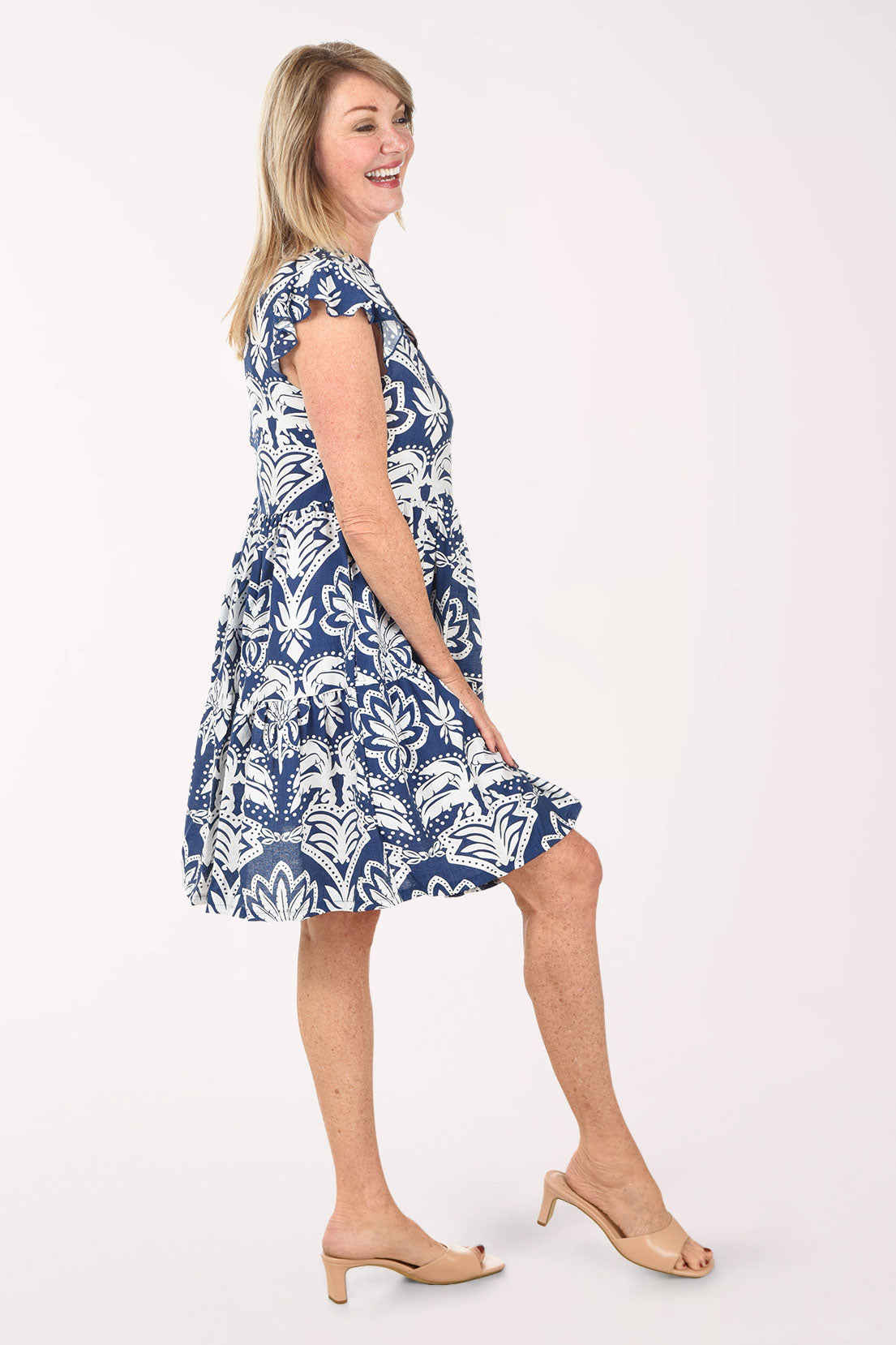 Woman wearing a blue and white patterned dress on a white background