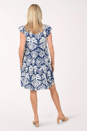 Woman wearing a blue and white patterned dress on a white background